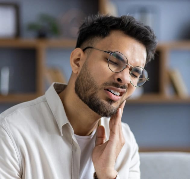 Man with tooth pain needing emergency dental care at Warwick Dental OKC