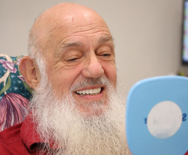 Senior patient checking dental implants at Warwick Dental OKC